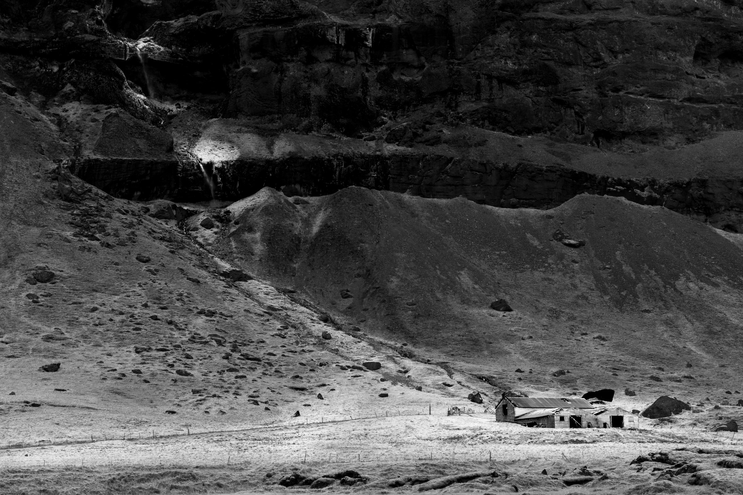 Lone farmstead beneath the cliff